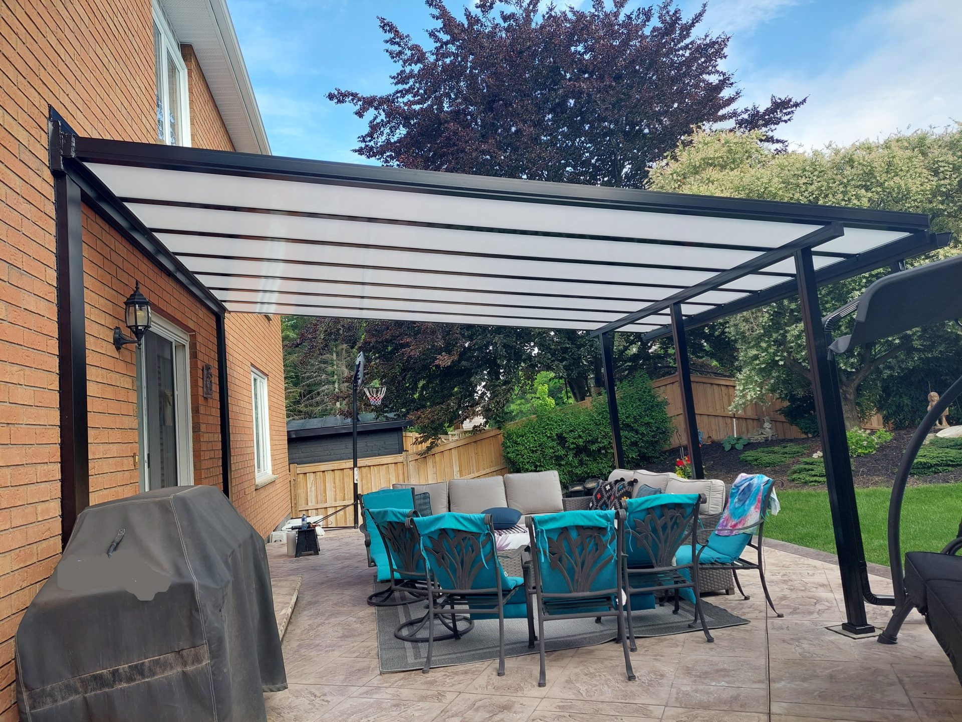 polycarbonate_patio_cover_on_brick_house_with_black_framing-5-scaled Toldo brazo articulado fijado a techo